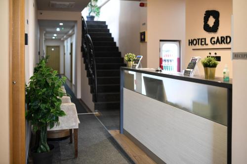 a hotel lobby with a reception counter and stairs at Hotel Garden in Novi Sad