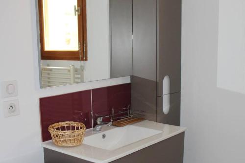 une salle de bain avec un lavabo et un miroir dans l'établissement Maison de campagne avec terrain, à Mialet