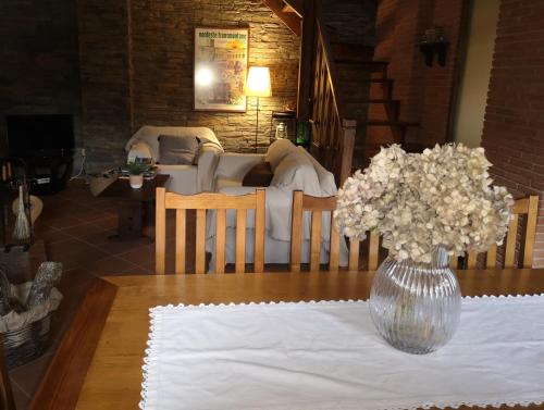 uma mesa com um vaso de flores sobre uma mesa em Casa do Parâmio - Montesinho em Parâmio