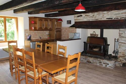 une cuisine avec une table en bois et une cheminée dans l'établissement Maison de campagne avec terrain, à Mialet
