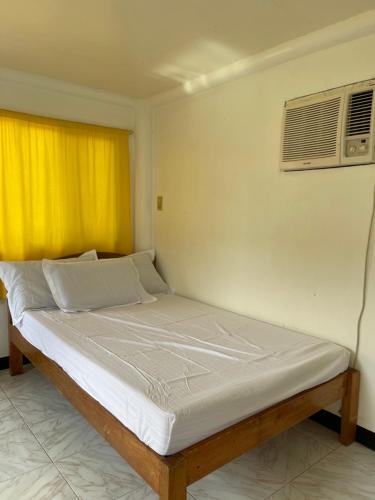a bed in a room with a air conditioner at Maria Kulafu Studio Apartment Kinamaligan- Beside Eglin Gas FREE Wifi in Masbate