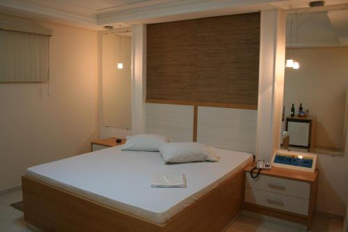 Schlafzimmer mit einem großen weißen Bett und einem Fenster in der Unterkunft Top´s Motel (Adult Only) in Jacareí