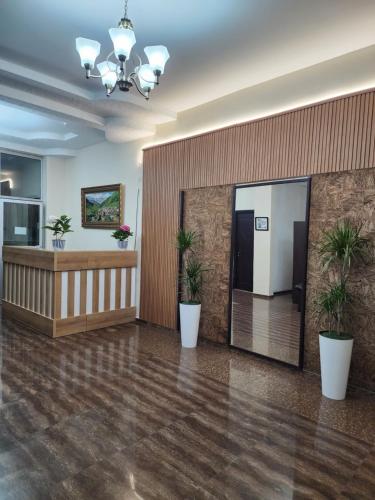 un vestíbulo de oficina con un espejo grande y macetas en Vizitori Hotel, en Gonio