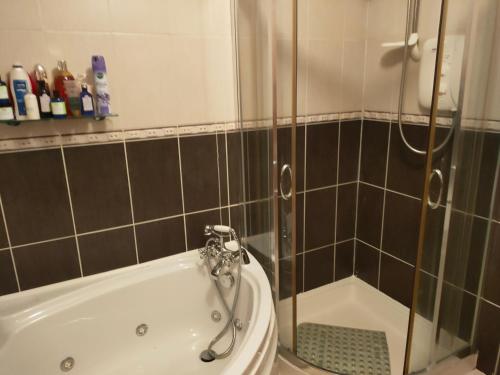 Das Bad ist mit einer Dusche und einer Badewanne ausgestattet. in der Unterkunft House in Miltown Malbay