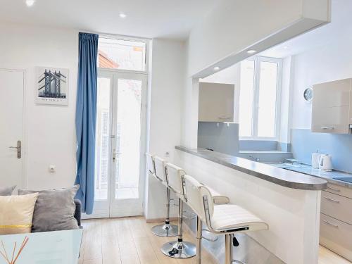- une cuisine avec un comptoir et des chaises dans la chambre dans l'établissement 1 Bedroom flat with Balcony Cannes Center Croisette 6ppl, à Cannes