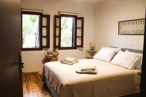 a bedroom with a bed with two towels on it at The Sisters Beach House in Diliso