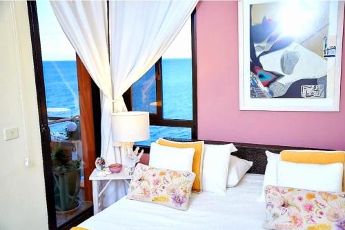 um quarto com uma cama com paredes cor-de-rosa e uma janela em Mouna's House em Tabaiba