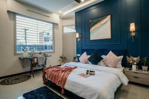 um quarto com uma cama com uma parede azul em 32 Avenue jodhpur em Jodhpur