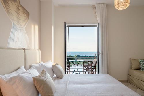 a bedroom with a bed and a view of the ocean at Drita Studios & Apartments in Svoronata