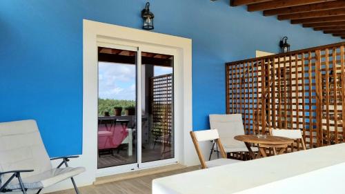 a room with a table and chairs and a blue wall at Herdade Monte Novo Do Pocinho in Cercal