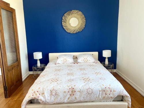 une chambre avec un lit avec un mur bleu dans l'établissement Nid urbain Colmarien - 4 personnes - garage, à Colmar