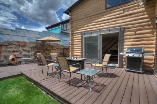 a deck with a table and chairs and a stove at Blessings in Creede