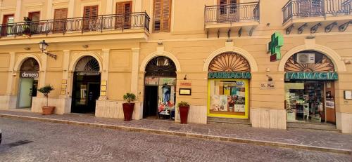 a yellow building with shops on a street at mama home in Agrigento