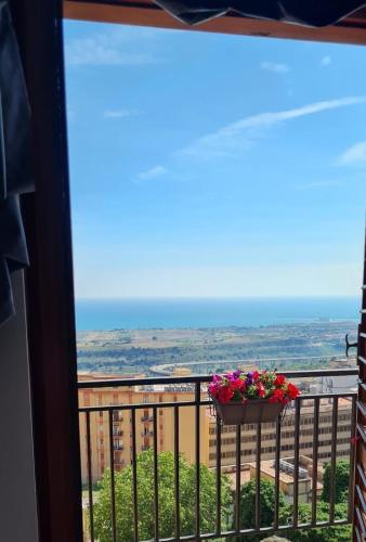 a balcony with a pot of flowers on a railing at mama home in Agrigento