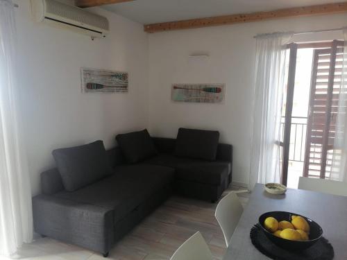 a living room with a couch and a table with a bowl of fruit at mama home in Agrigento