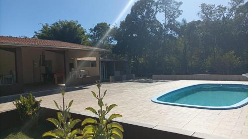 a swimming pool in a yard next to a house at Pousada Dedo de Deus in Paraisópolis