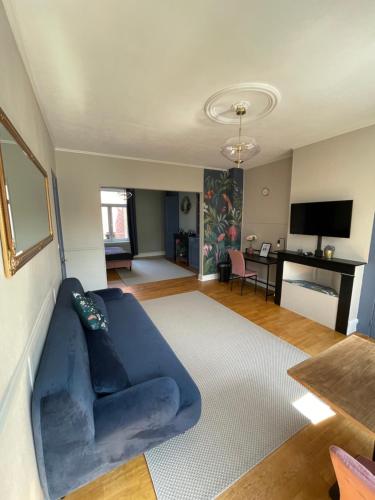 a living room with a blue couch and a table at Villa Artiz in Dunkerque