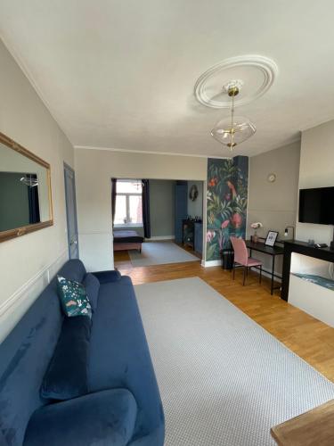 a living room with a blue couch and a table at Villa Artiz in Dunkerque