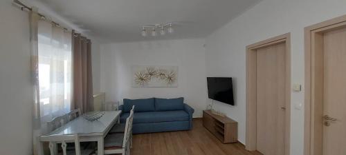 a living room with a blue couch and a table at Aeropis Villa, Chania in Chania