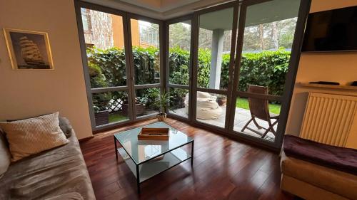 a living room with a couch and a glass table at Apartament Willa Woda in Jurata