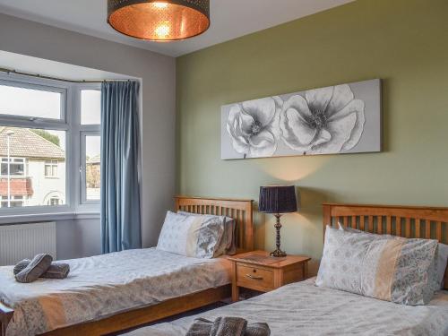 a bedroom with two beds and a window at Markham House in Radipole