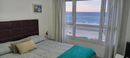 um quarto com uma cama e vista para o oceano em Ventana al Mar em Puerto Madryn