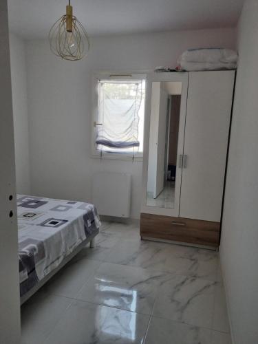 1 dormitorio con cama, ventana y espejo en Bel Appartement Frejus, en Fréjus