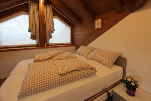 a bedroom with two beds and two windows at Affittacamere Mercedes in Romallo