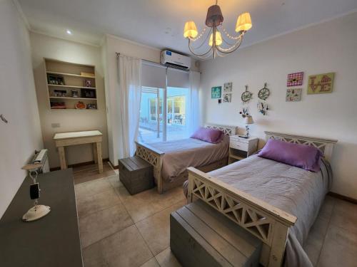 a bedroom with two beds and a window at Casa en Club de Campo. Parque y Pileta. in San Nicolás de los Arroyos