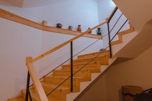 uma escada numa casa com um corrimão de madeira em Pensiunea La Maison Verte em Pietroasa