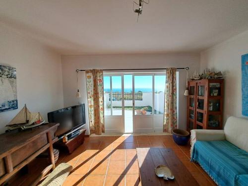 uma sala de estar com um sofá e uma televisão em Sunset House Porto de Barcas - 3 rooms & Terrace na Lourinhã