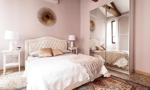 Schlafzimmer mit einem weißen Bett und einem Spiegel in der Unterkunft Ca' della scala in Venedig