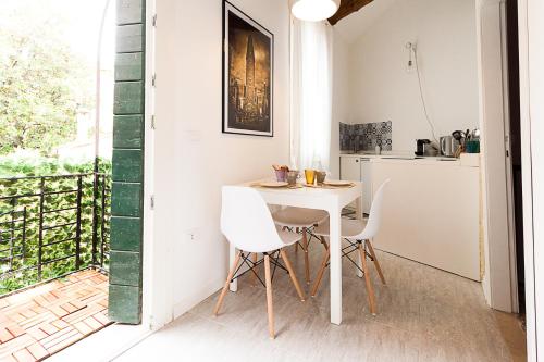 eine kleine Küche mit einem weißen Tisch und Stühlen in der Unterkunft Ca' della scala in Venedig
