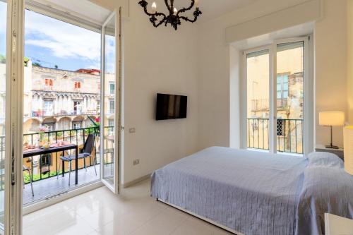 een slaapkamer met een bed en een balkon bij CloisterVista apartment in Napels