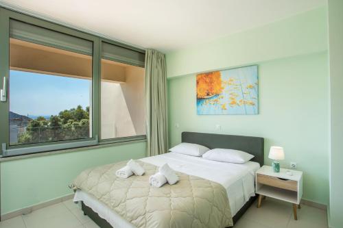 a bedroom with a bed and a window at Eden Sunflower - Luxurious Apartment with Sea View in Rhodes Town