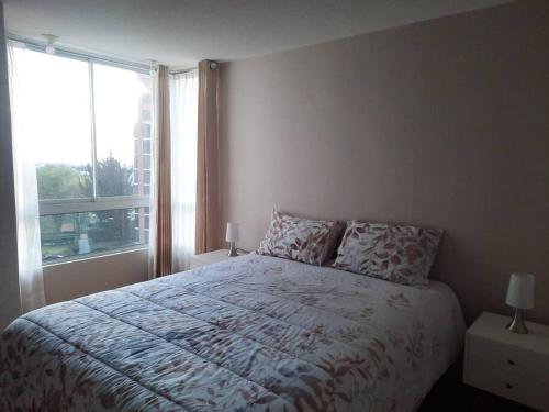a bedroom with a bed and a large window at Hermoso dpto en condominio residencial en estreno in Paucarpata