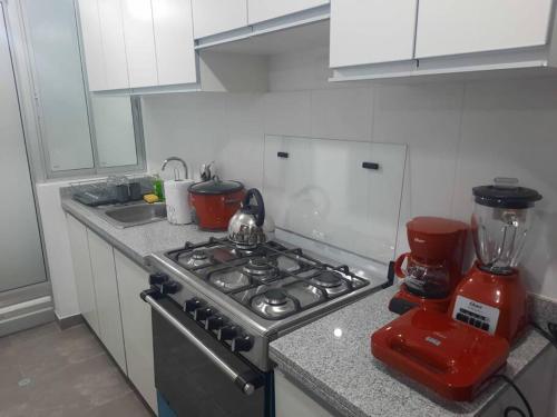 a kitchen with a stove and a blender on a counter at Hermoso dpto en condominio residencial en estreno in Paucarpata