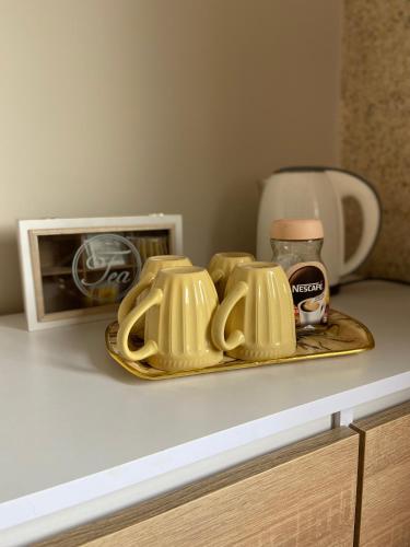 a tray with four tea cups on a counter at Mira - Mira pokoje z widokiem na jezioro in Chmielno