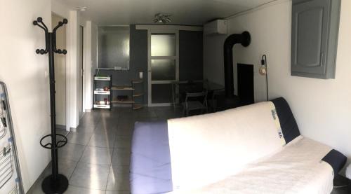 a bedroom with a bed and a room with a table at Le pti logis in Laveyron