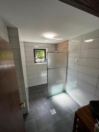 a shower stall in a bathroom with a window at Rooms and apartments Biš 