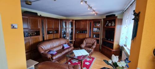 sala de estar con sofás de cuero y mesa en Vila Biba - Ilijas, en Ilijaš