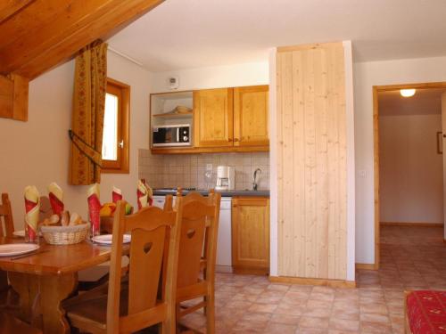 une cuisine et une salle à manger avec une table et des chaises dans l'établissement Appartement pour 6 au centre de Lanslevillard, proche des pistes avec balcon et WIFI - FR-1-508-15, à Lanslevillard