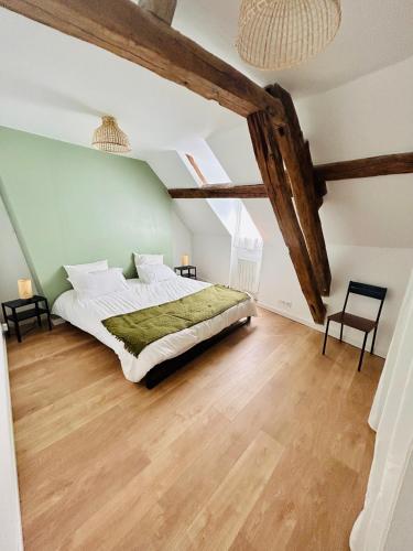 a bedroom with a large bed in a attic at Appartement Cottage au cœur de Nemours in Nemours