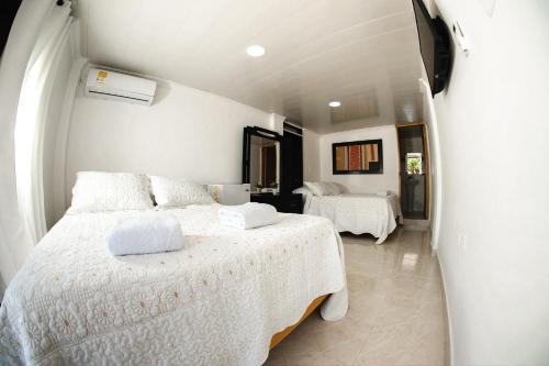 a bedroom with two beds with white sheets at Hotel Campestre Dorado SAI in San Andrés