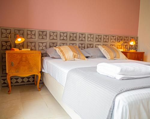 um quarto com 2 camas e uma mesa com 2 candeeiros em Dionysia Premium Suites em Argostoli