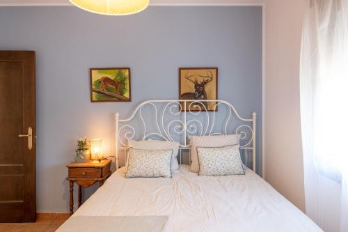 a bed with a blue headboard in a bedroom at Casa Rural Emilio con 4 dormitorios in Málaga