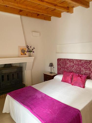 1 dormitorio con 1 cama grande con sábanas rosas en Casa de pueblo con encanto para desconectar, en Terque