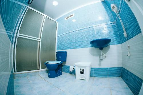 a bathroom with a blue toilet and a sink at Hotel Campestre Dorado SAI in San Andrés
