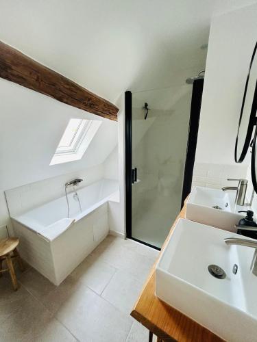 a bathroom with a tub and a sink and a shower at Appartement Cottage au cœur de Nemours in Nemours