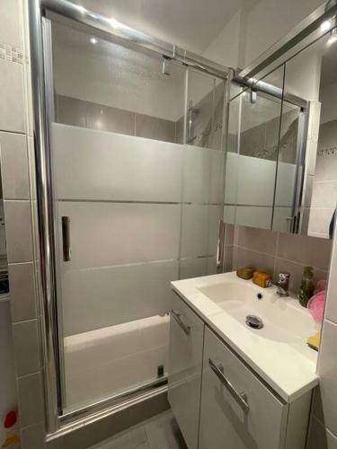 une salle de bain blanche avec une douche et un lavabo dans l'établissement 200 m de la plage jardin calme, à Saint-Mandrier-sur-Mer